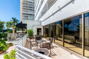 Enjoy ocean views from this balcony with outdoor seating, a fire pit, and lush greenery.