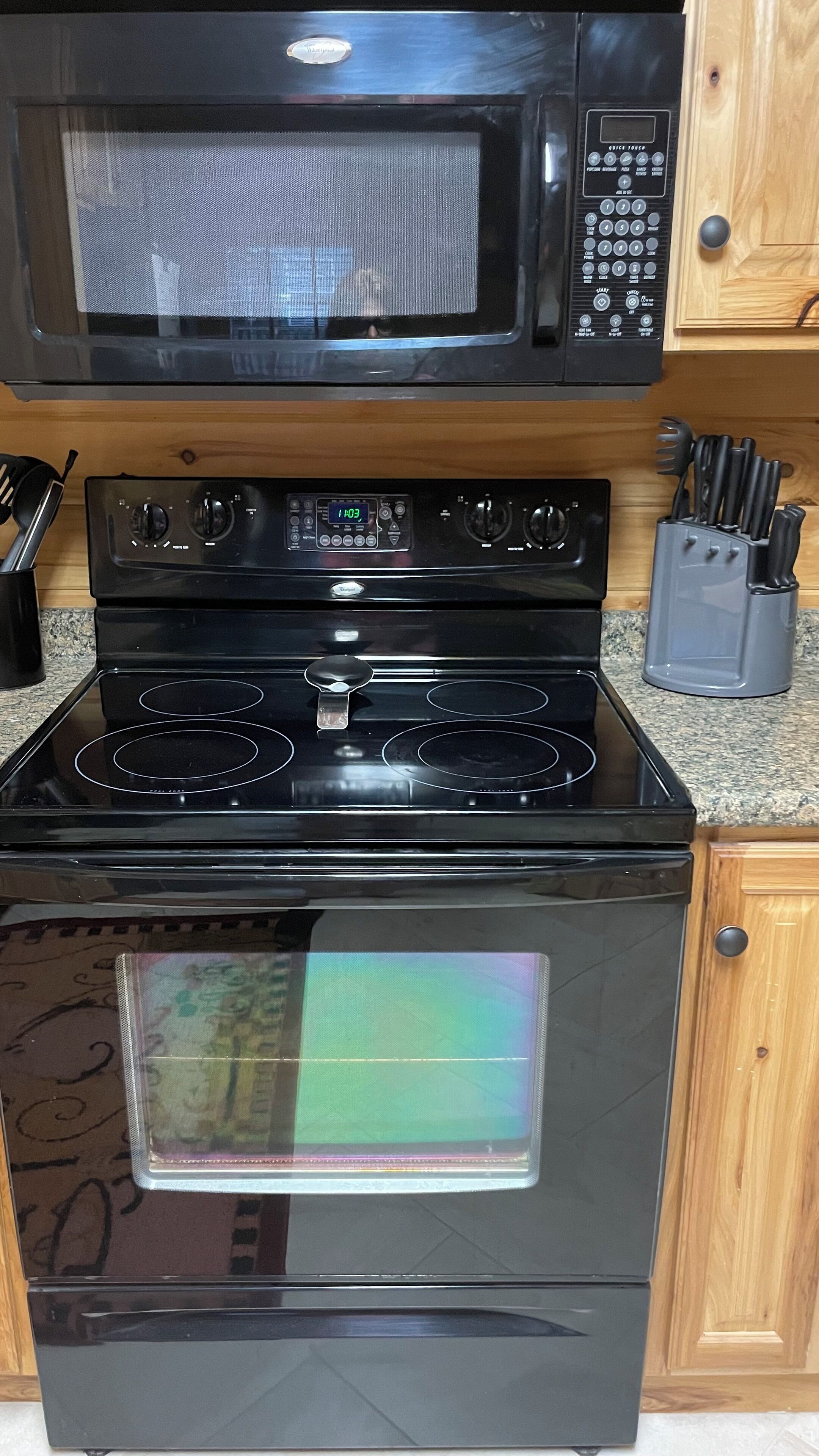 Una cocina con estufa, horno y microondas negros.