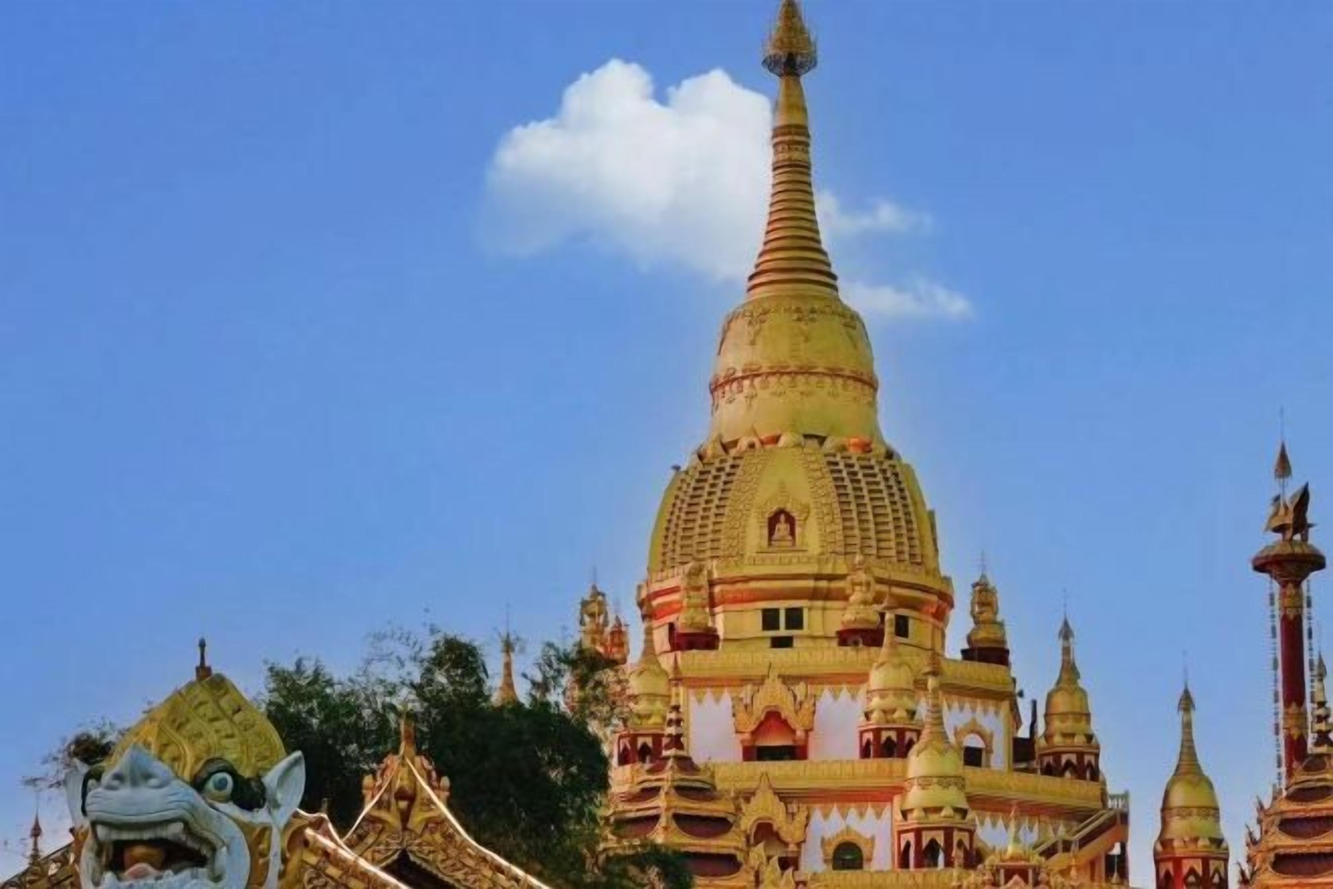 Une grande structure de style pagode, de couleur dorée, à plusieurs niveaux et surmontée d’une flèche pointue.