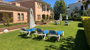 Un cortile con posti a sedere all'aperto e un edificio con finestre ad arco.