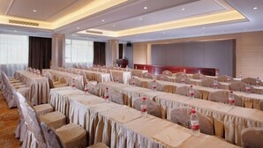 A conference room with rows of tables and chairs, equipped with water bottles and name cards. - Vienna Hotel (Yangshuo West Street Qianguqing Branch) (Yangshuo)