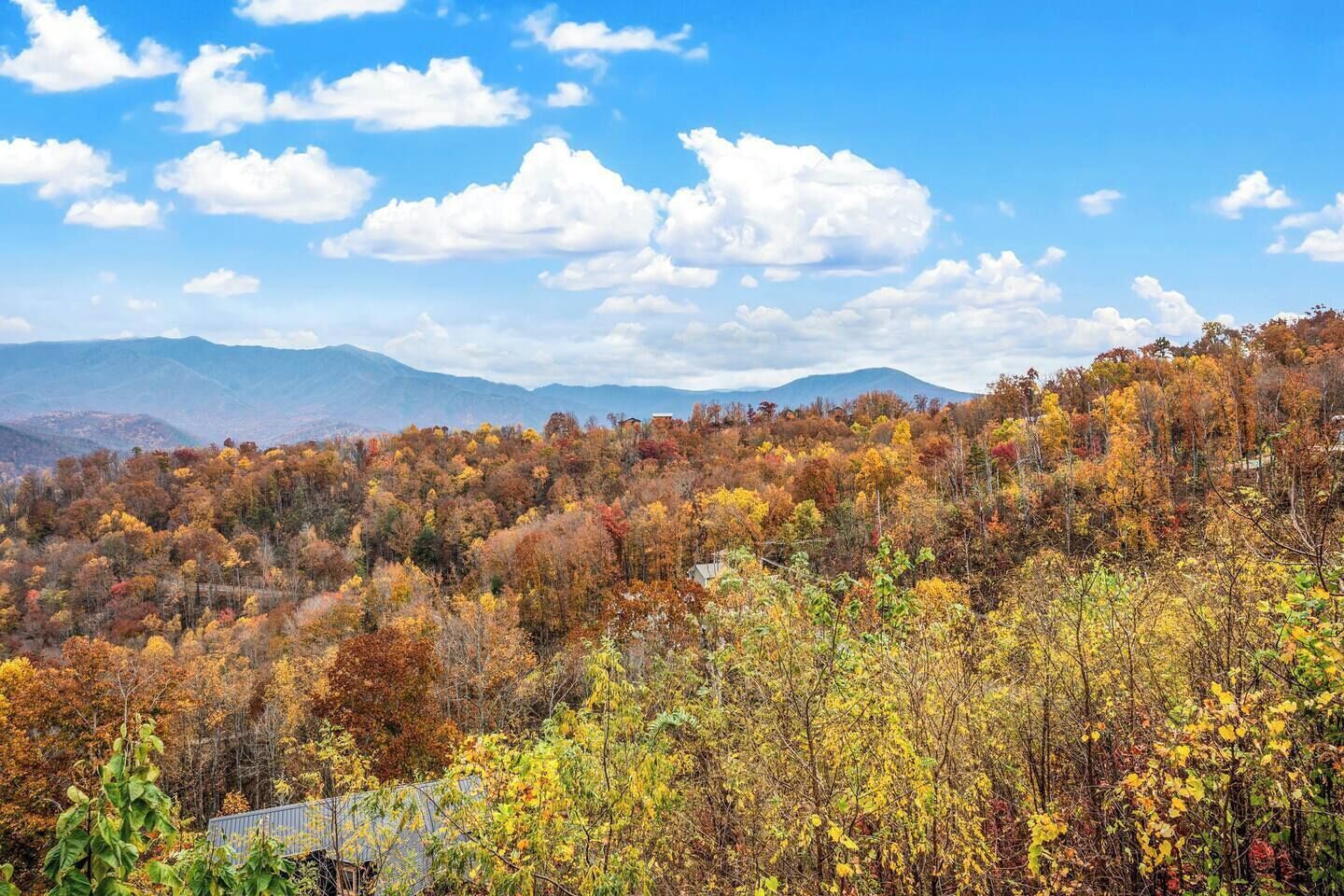 A mountainous landscape with autumn foliage and a clear sky.