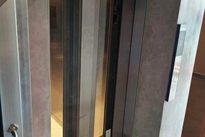 A door with a metallic handle and a glass panel, likely leading to a room or hallway. - Ramos Hello Stay Cebu (Cebu City)