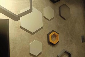 A wall with geometric shapes, including hexagons and rectangles, in a neutral color palette. - Ramos Hello Stay Cebu (Cebu City)