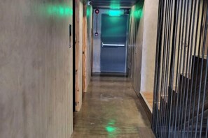 A narrow hallway with a wooden door on the left and a metal gate on the right. - Ramos Hello Stay Cebu (Cebu City)