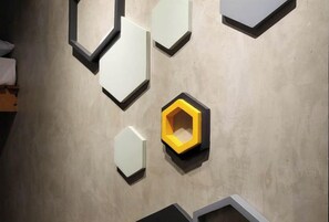 A wall with geometric wall art and a bed. - Ramos Hello Stay Cebu (Cebu City)