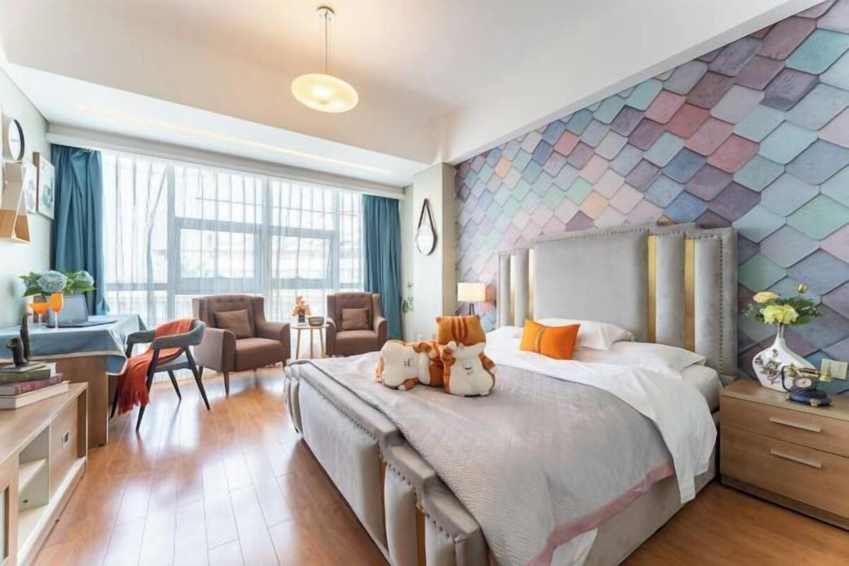 Ein modernes Hotelzimmer mit einem großen Bett, einem Schreibtisch und einem Sessel.