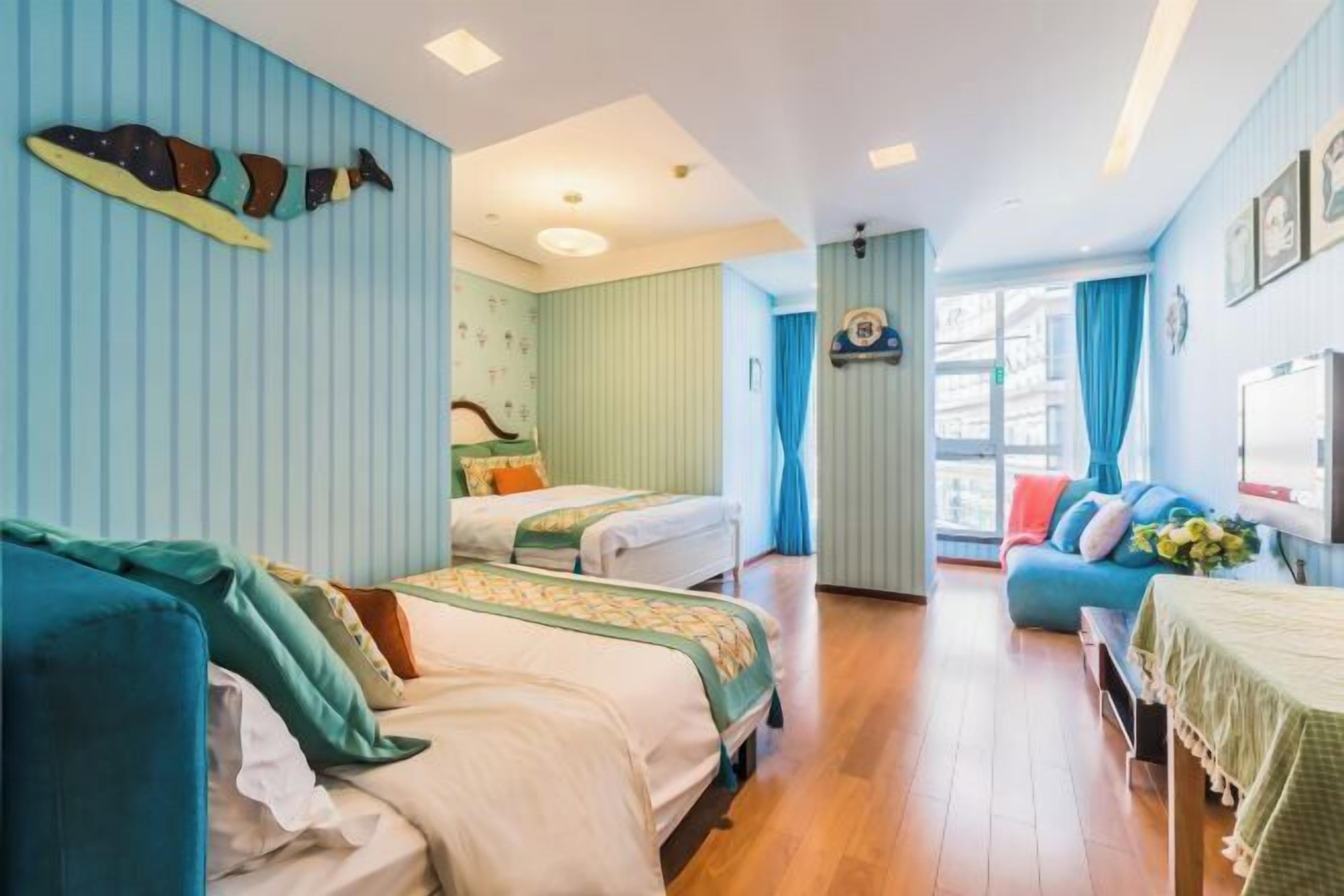A hotel room with two beds, a sofa, a window with curtains, and a wall-mounted decoration.
