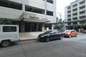 A building with a sign reading 'bel-air soha' and a parked car in front. - RedDoorz @ TJMG by Bel Air Polaris Makati (Makati)