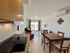 Enjoy meals in the well-lit kitchen and dining area, featuring a cooktop and dining table.