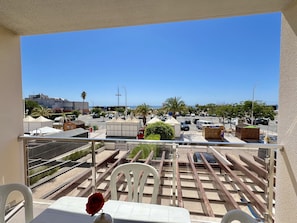 Enjoy a serene view of the beach from this balcony, featuring a table and two chairs.