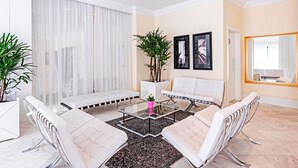 A modern living room with a sofa set, a coffee table, and a large mirror.