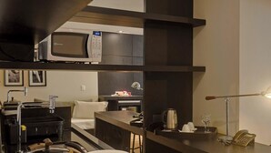 A modern kitchen with a microwave, a coffee machine, and a telephone on the counter.