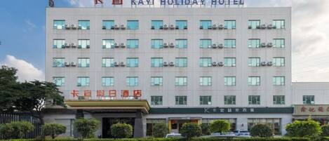 A multi-story hotel with a modern facade, featuring a prominent sign at the top.