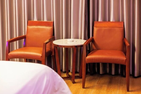 Ein Hotelzimmer mit zwei Ledersesseln und einem kleinen runden Tisch.