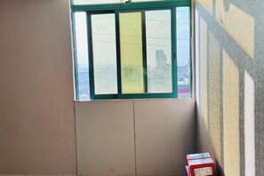 A room with a window, a door, and a box on the floor. - Kayi Hotel (Dongguan)