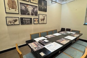 A conference room with a long table, chairs, and framed pictures on the wall. - Kayi Hotel (Dongguan)