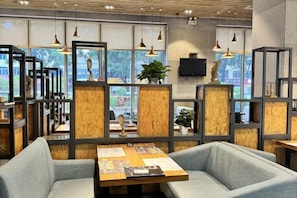 A modern interior with seating areas, wooden partitions, and pendant lighting. - Kayi Hotel (Dongguan)