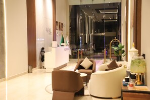 A modern reception area with a reception desk, seating area, and a decorative lamp. - Afal Serviced Apartments - Al-Munsiyah (Riyadh)