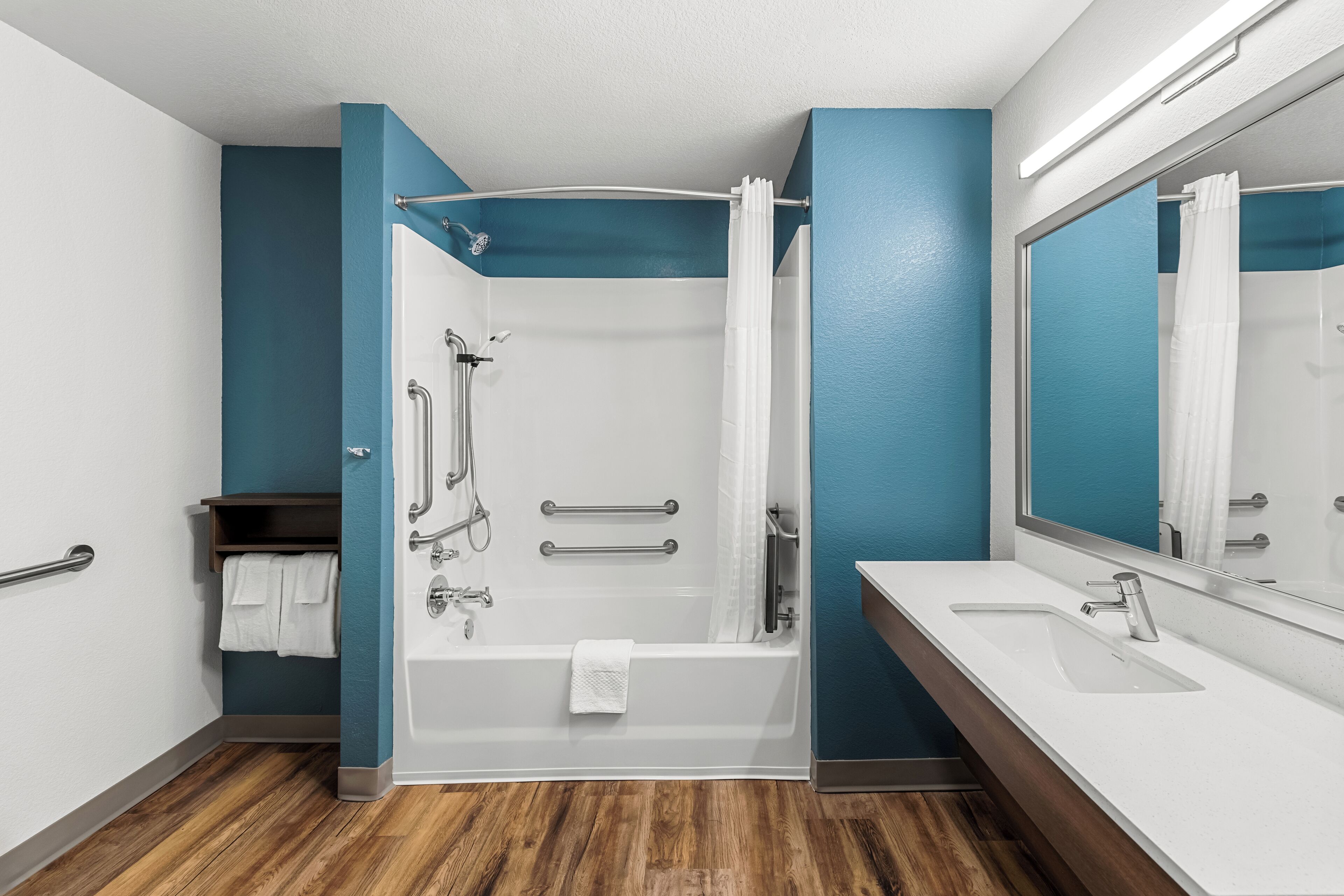 A modern bathroom with a bathtub, shower, and two sinks.