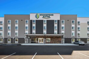 A modern hotel with a flat roof, a central entrance, and a parking lot in front. - Woodspring Suites Columbia - Irmo (Irmo)