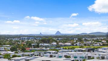 A residential area with modern houses, a clear sky, and distant mountains.