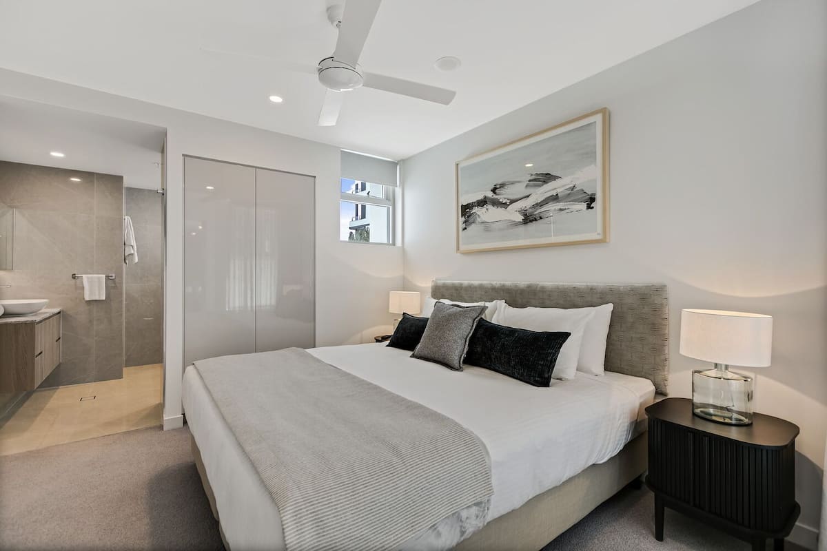 Relax in a spacious room with a large bed, two bedside tables, and a walk-in closet.