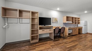 A compact living space with a kitchenette, a dining area, and a workspace. - WoodSpring Suites St Peters-OFallon (St. Peters)
