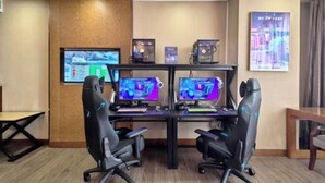A gaming setup with two monitors, two gaming chairs, and a desk. - Rufu Hotel (Ganzhou)