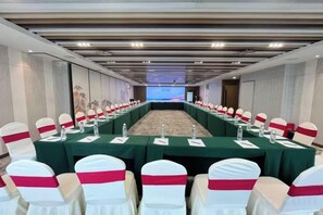 A conference room with a long table, chairs, and a projection screen. - Rufu Hotel (Ganzhou)