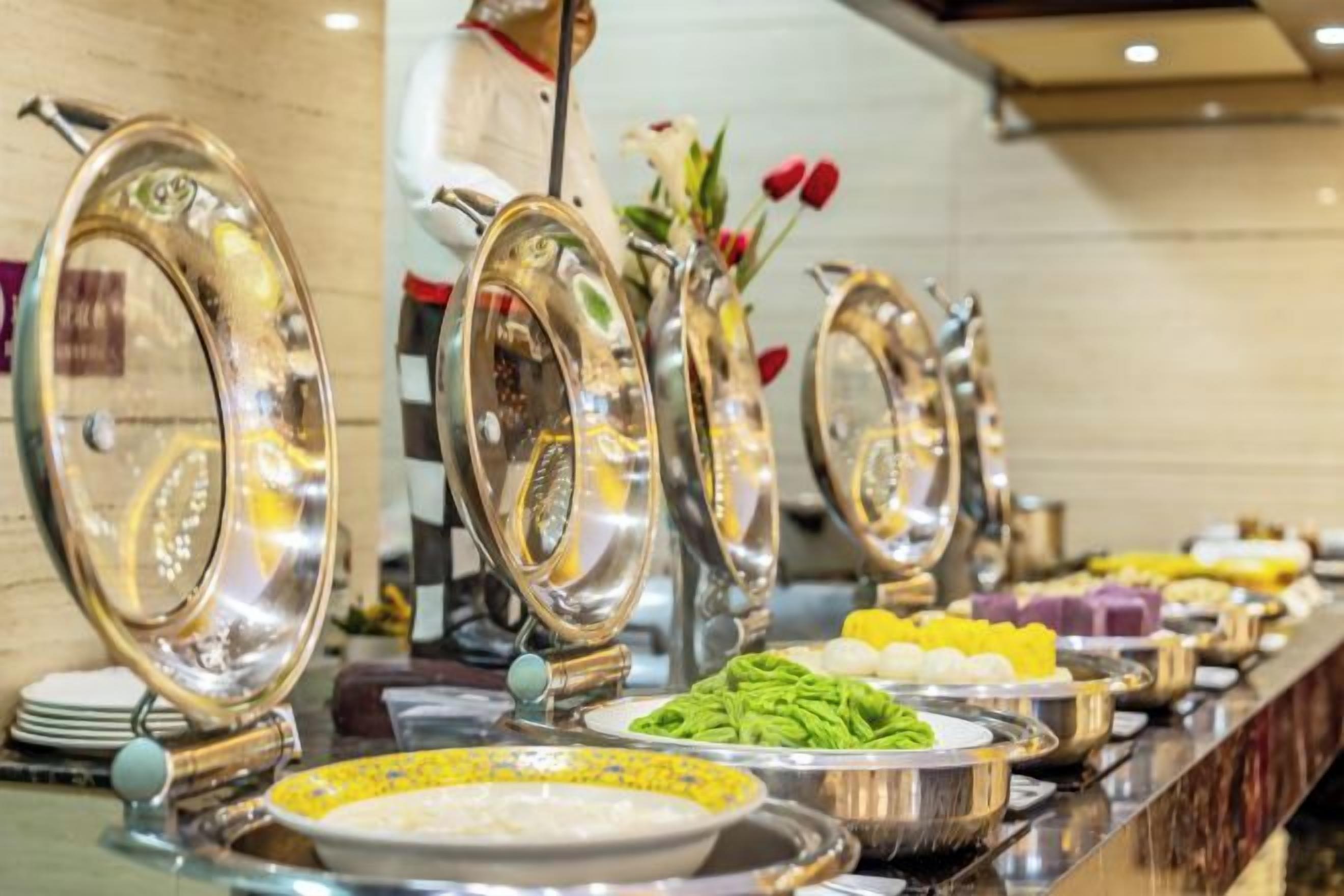 A buffet setup with multiple food stations and serving utensils.