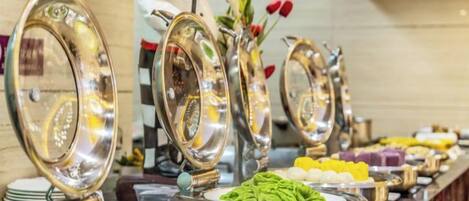 A buffet setup with multiple food stations and serving utensils.