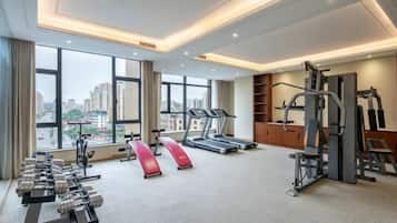 A gym with treadmills, weight machines, and dumbbells.
