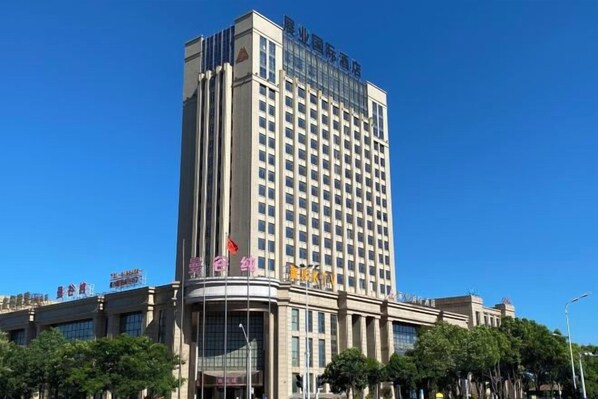 A tall hotel building with a prominent entrance and multiple floors.