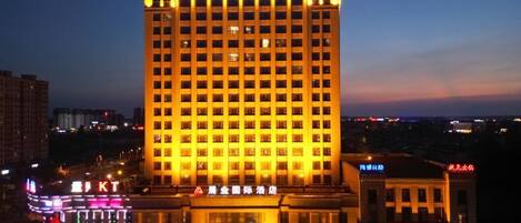 A multi-story hotel with illuminated signage and a prominent entrance.