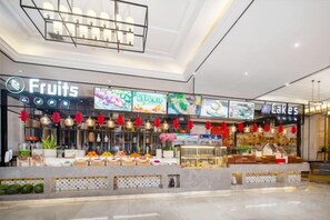 A food court with a Fruits section and a Cakes section, featuring various food displays and hanging decorations.