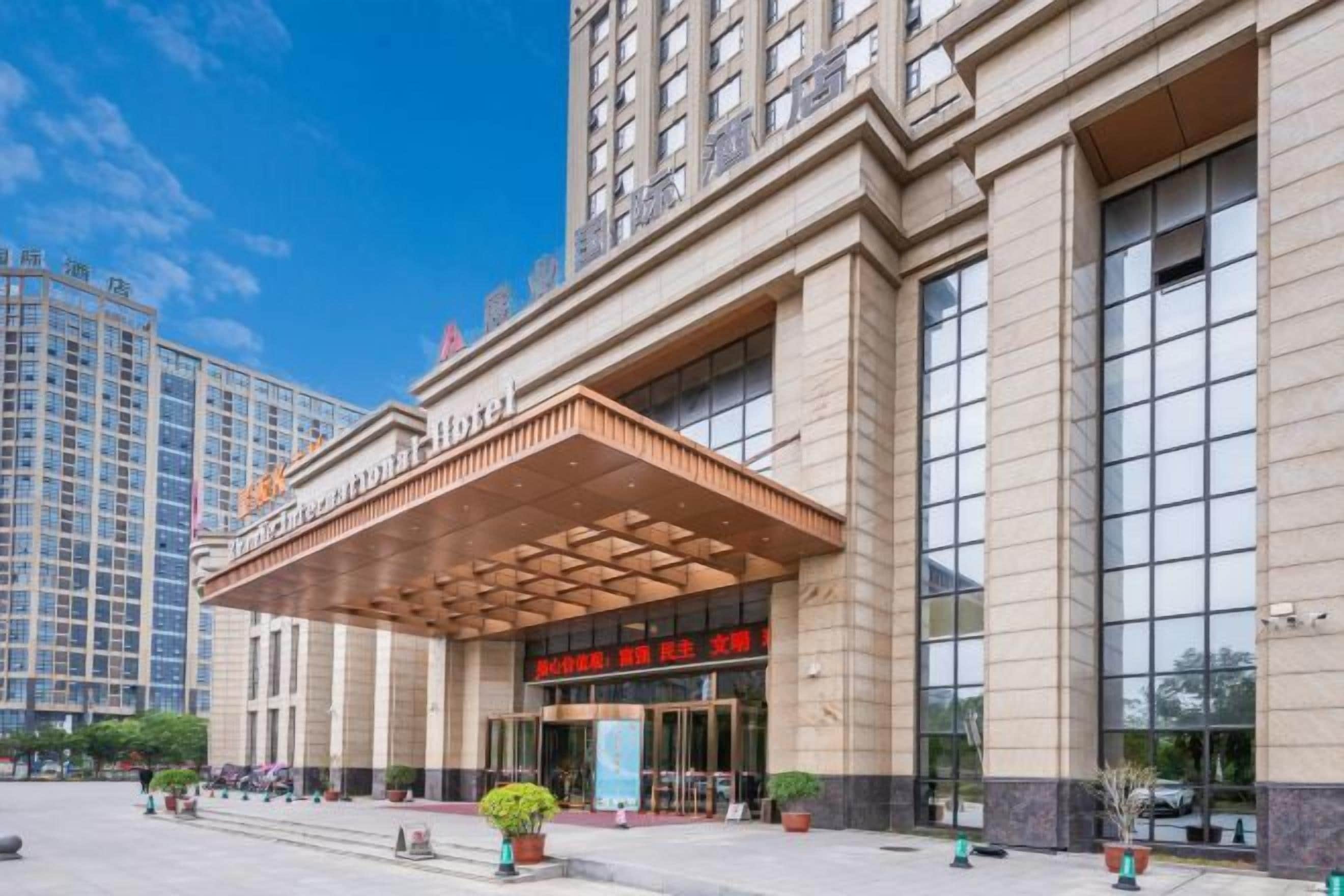 A large hotel with a prominent entrance, a covered area, and a modern facade.