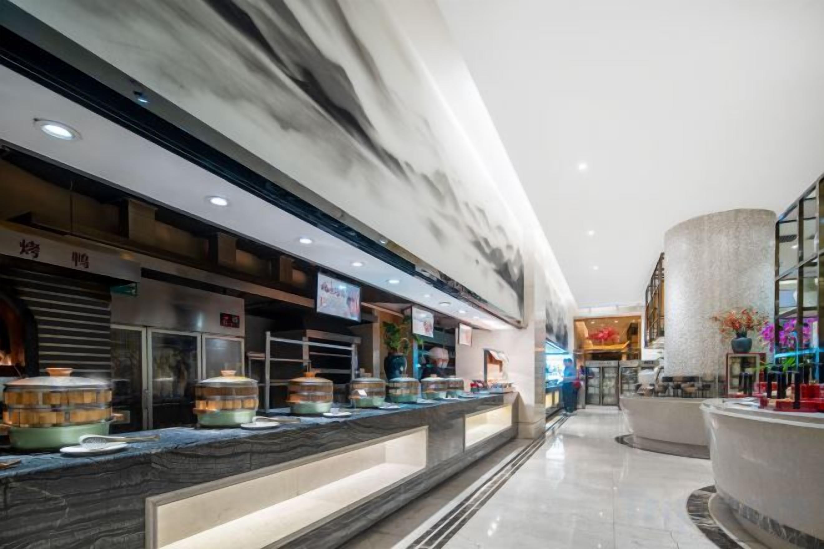 Et hotel lobby med en skrivebord i marmor, en stor søjle og udsigt over interiøret.