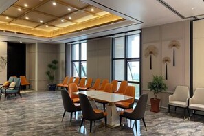 A conference room with a long table, chairs, and a ceiling with recessed lighting.