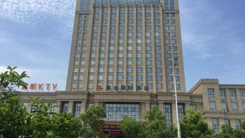 A multi-story building with a large number of windows and a sign indicating it is a hotel.