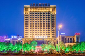 A multi-story hotel building with a prominent sign at the top.