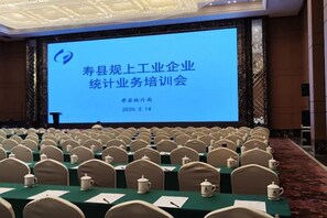 A conference room with rows of chairs facing a large screen displaying text. - Zhan Ye International Hotel (Shou County)