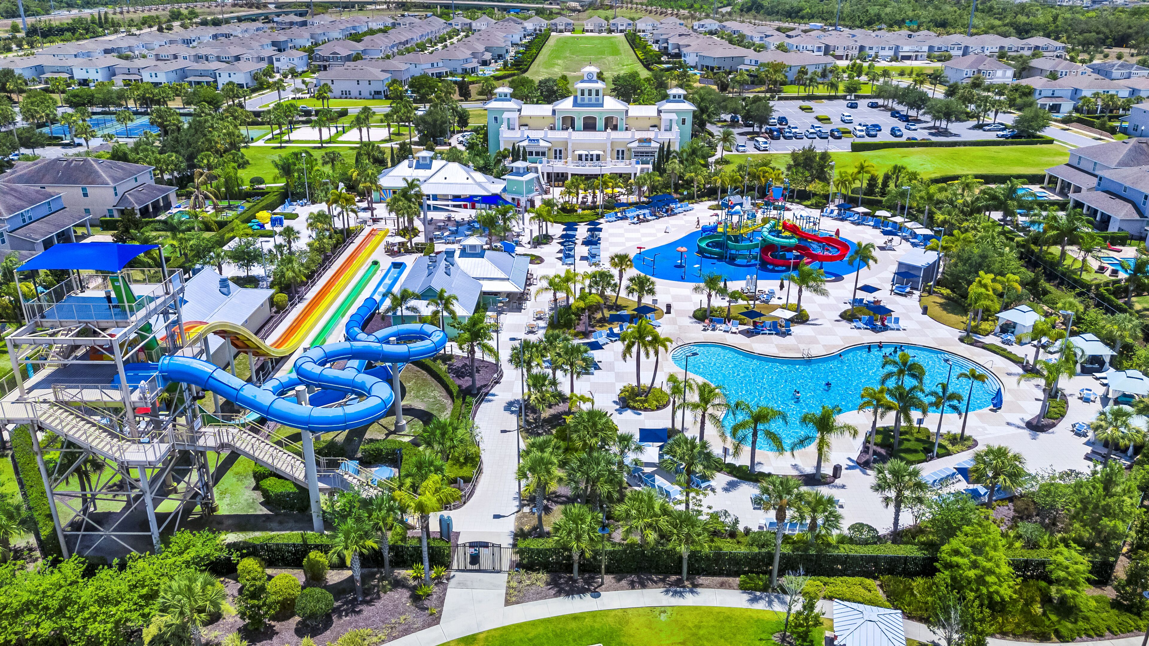 A resort with a large pool, water slides, and a tennis court.
