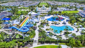 A resort with a large pool, water slides, and a tennis court.