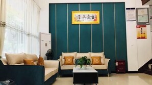 Uma sala de estar com dois sofás, uma mesa de centro e um quadro pendurado na parede.