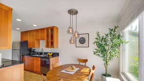 A modern kitchen with wooden cabinets, a central island, and pendant lighting. - Pool, 2 Mi to Beach! Extended Stay in San Diego (San Diego)