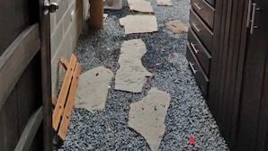Ein schmaler Korridor mit Fliesenboden, einer kleinen Sitzecke mit einer Bank und einer Toilette.
