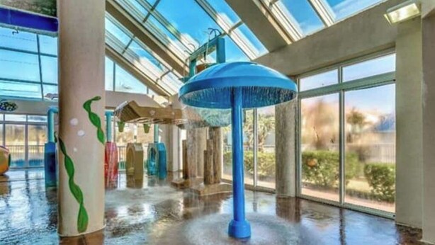 Un'ampia area interna con una grande vasca d'acqua e un tetto in vetro che fa entrare luce naturale.