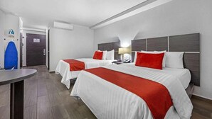 A hotel room with two beds, each with white bedding and red accents, a bedside table with a lamp, and a small desk with a chair. - BeWow Hotel Querétaro (Querétaro)