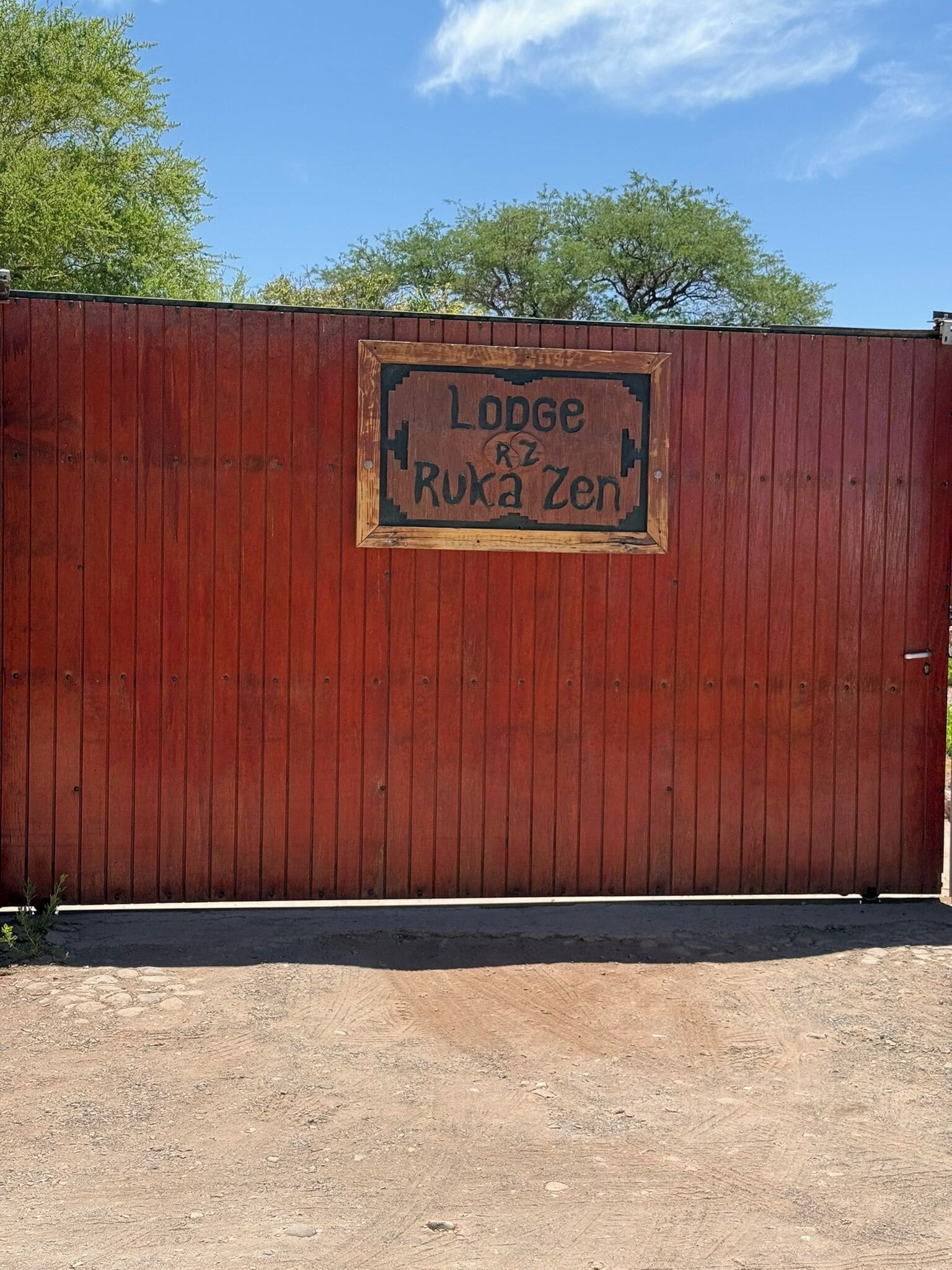 A wooden fence with a sign that reads "Lodge Ruka Zen".